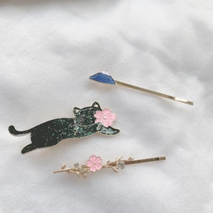 Detail of Japanese hair clips set with Mount Fuji, black cat and pink cherry blossoms