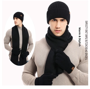 Detailed knit texture and brown leather patch on winter beanie, scarf and gloves set