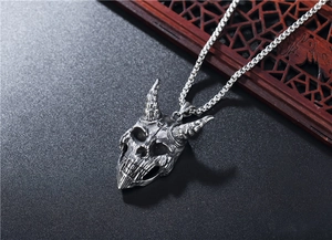Gros plan du pendentif crâne de monstre rétro en argent avec chaîne en acier robuste