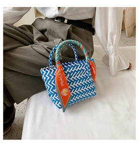 Détail d'un sac panier en paille avec poignée en foulard de soie motif Peace