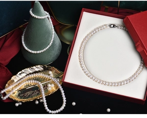 Detailed view of high-quality white freshwater pearl necklace in a red jewelry box