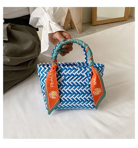 Détail du sac tressé bleu et blanc avec poignées en foulard à imprimé floral PEACE