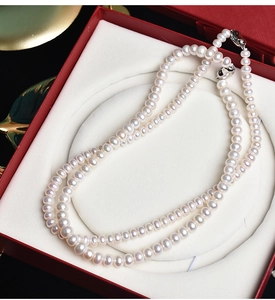 Macro shot of high-quality white round freshwater pearl necklace in a red jewelry gift box
