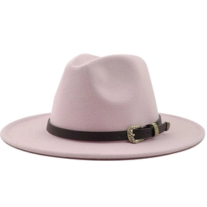 Detail of light pink fedora hat featuring dark brown leather strap and vintage gold buckle