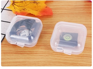 Close-up of small clear plastic storage cases with snap lids on a wooden tabletop