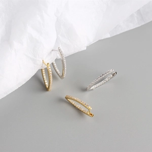 Detail showing gold and silver S925 sterling silver geometric hoop earrings with clear stones