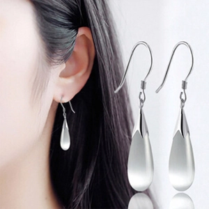 Close-up of teardrop catseye stone earrings on model showing silver hook details