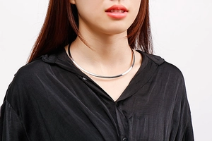 Close-up of polished silver titanium steel choker necklace on a female model