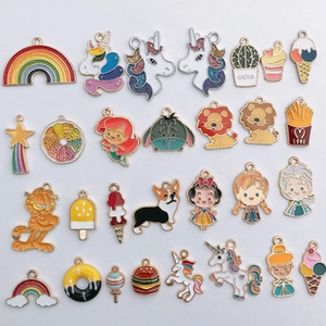 Flat lay of 26 colorful enamel pendants including food characters and animal shapes
