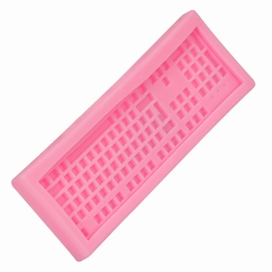 Pink silicone keyboard mold for DIY chocolate and fondant crafting on a white background