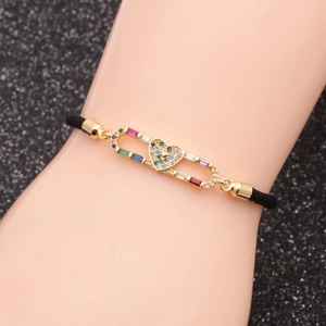 Detail of copper heart bracelet with colorful zircons on a black braided cord