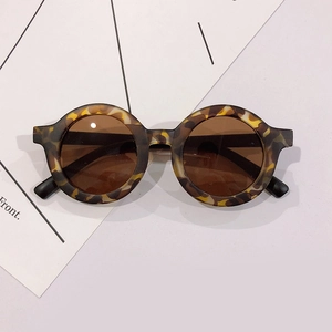 Detail view of round leopard print children's glasses frames on a white background