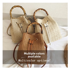 Close-up of woven straw bucket bags featuring bamboo handles and drawstring closures