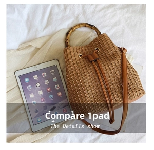 Detail view of straw bucket bag size comparison with an iPad and bamboo handle