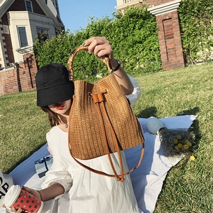 Straw bucket bag with bamboo handles and leather drawstring for summer vacation
