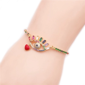 Adjustable golden bracelet with zircon evil eye and red heart pendant worn on wrist
