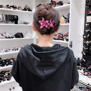 Detail of elegant fuchsia rhinestone flower hair clip used for elegant bun hairstyles