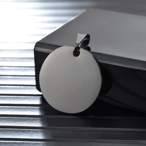 Close-up of polished stainless steel blank round tag with hole for DIY laser engraving