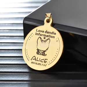Macro shot of gold-plated stainless steel pet ID tag featuring custom cat engraving