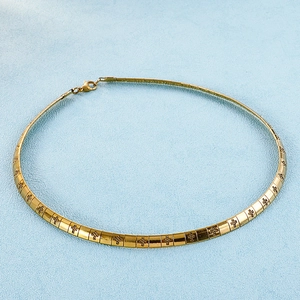 Minimalist gold titanium steel choker necklace with engraved cross pattern on blue background