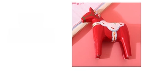 Macro detail of red wooden Dala horse featuring traditional Kurbits hand-painted floral art