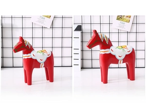 Comparison view of large and small red wooden Dala horse statues with Nordic floral patterns
