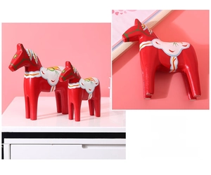 Detail view of two red Dala horses with traditional Nordic hand-painted floral patterns