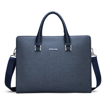 Détail de la sacoche en cuir gris texturé avec poignées bleues et logo argenté