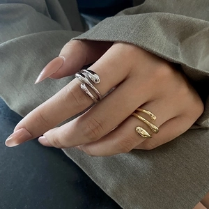 Minimalist teardrop open rings in gold and silver finish styled as a stacked set on hand