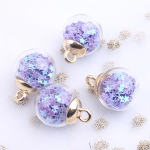Detail shot of clear glass balls with purple and blue star sequins and gold metal rings