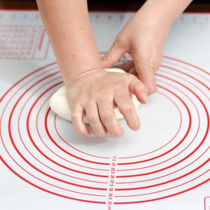 Macro shot of hands kneading dough on a platinum silicone mat with circular scales