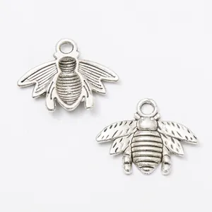 Detailed macro of vintage silver bee charms with intricate wing textures for DIY jewelry