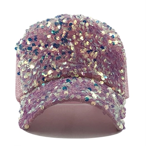 Close-up of pink iridescent sequins on a mesh baseball cap with shimmering light effects