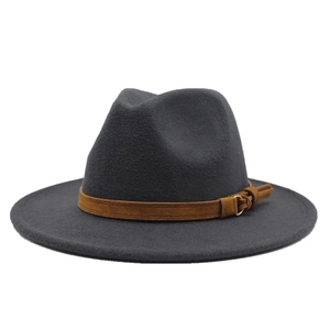 Close-up of wool felt jazz fedora with brown leather buckle band detail on gray surface