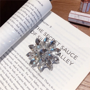 Macro shot of sparkling flower crystal phone grip stand on a vintage book surface