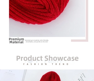 Close-up of red thick knit beanie showing textured cable knit patterns and warm wool yarn
