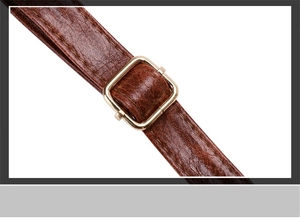 Macro shot of vintage brown leather texture and gold adjustable metal buckle detail