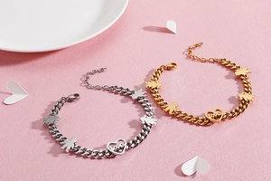 Detail of silver and gold heart bracelets with love charm and girl boy silhouettes