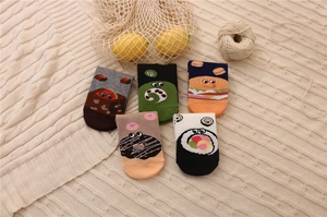 Close-up of colorful cartoon food pattern cotton ankle socks on a cozy knitted blanket