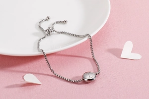 Detail view of silver Aries zodiac charm on an adjustable titanium steel bracelet