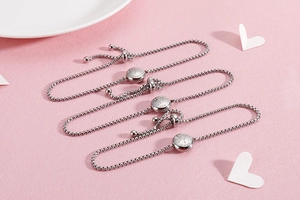 Detailed view of silver zodiac bracelets with adjustable box chains and engraved charms
