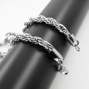 Pair of polished stainless steel twist rope chains with secure lobster clasps on a display