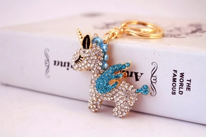 Detailed close-up of a golden unicorn keychain with sparkling blue and white crystals