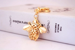 Detailed view of golden bee keychain with lobster clasp and intricate mesh wing design