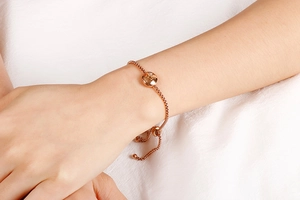Adjustable rose gold snake chain bracelet with sparkling round pendant on female wrist