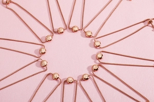 Detailed view of adjustable rose gold zodiac pendants with crystals on bead chains