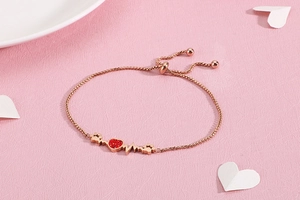 Macro shot of rose gold heartbeat bracelet with red heart stone and adjustable clasp