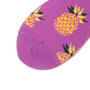 Calze in cotone viola con motivi di ananas gialli su un pulito sfondo bianco
