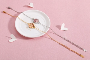 Détail de joncs ajourés motif rose en finitions or et argent sur fond rose