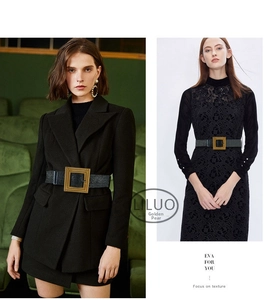 Detail of wide black leather belt with textured gold square buckle on dress and coat